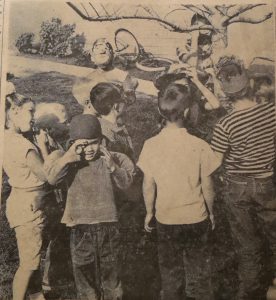 COMPLETE WITH A STRONG MAN, clowns, tight rope walker and puppeteers, a one-ring circus was presented by four for the younger set on Aliso street Saturday afternoon. Shown above, the kids guessing how many marbles are in the jar. 