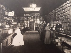 George W. Mallory standing behind counter on the right. This photo was taken in 1905 of the Mallory - Dennison Store. 